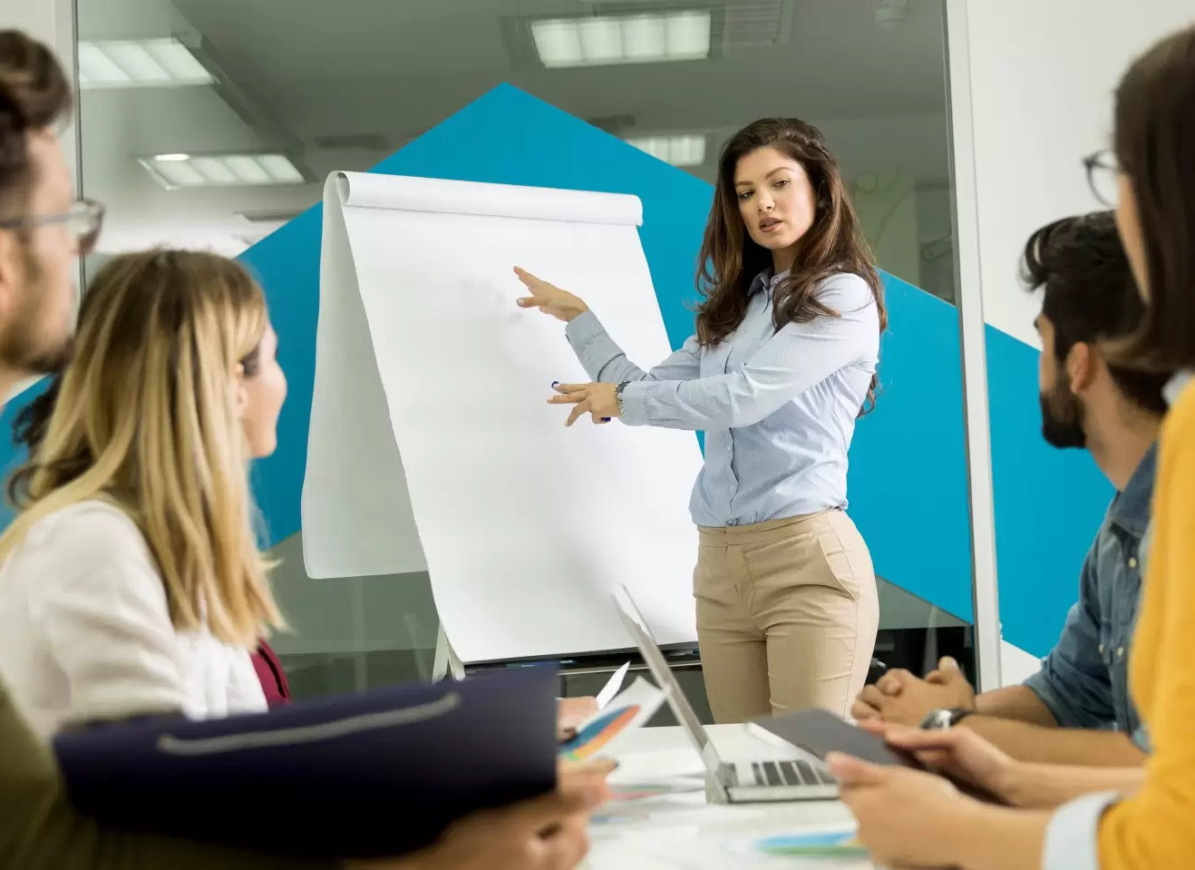 Formadora impartiendo una sesión de formación bonificada para empresas, explicando contenidos en una pizarra ante un equipo profesional en un entorno corporativo.