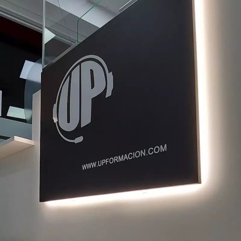 Panel interior con el logotipo de UP Formación y la dirección web oficial, integrado en la señalética del centro formativo.